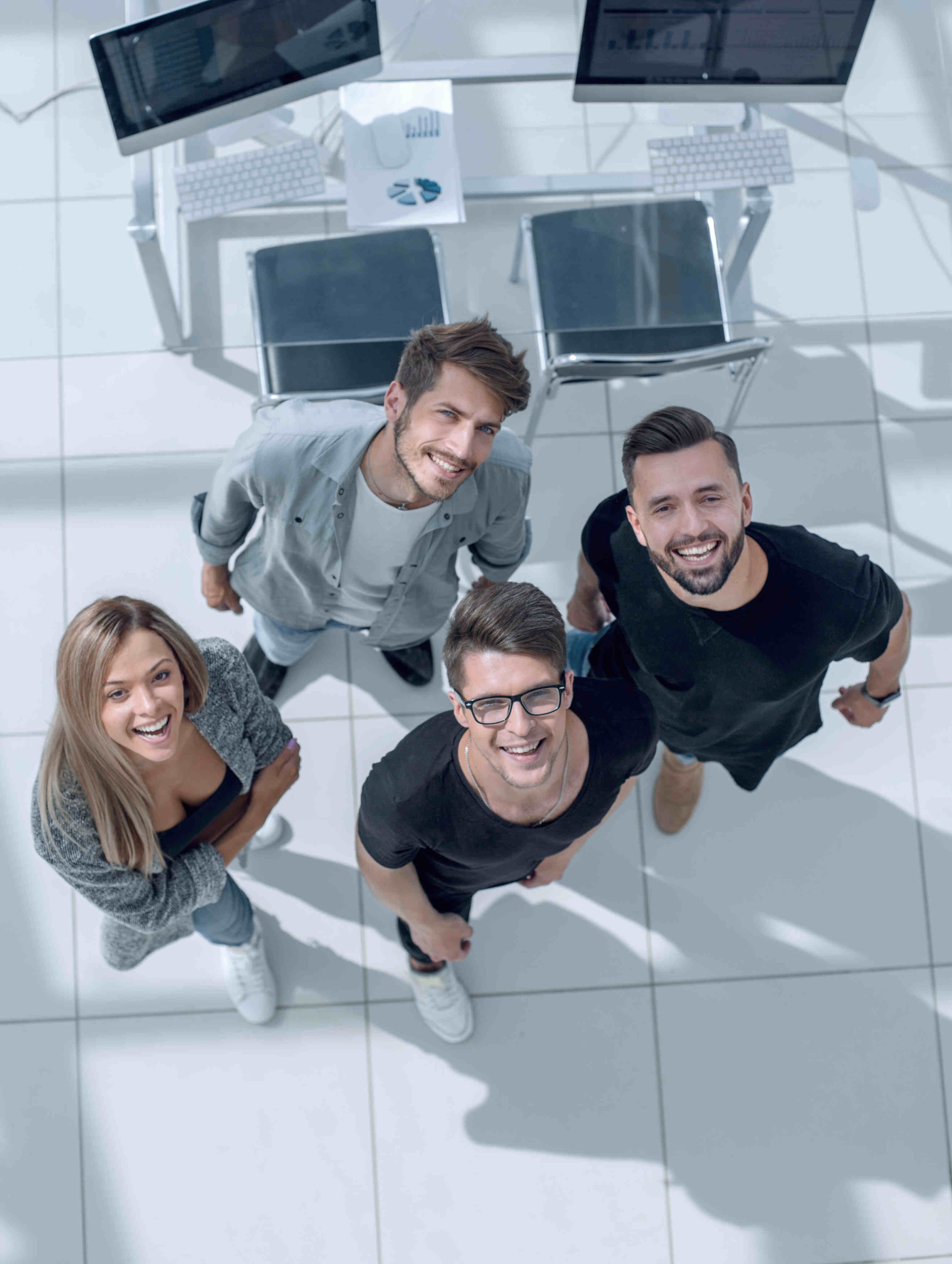 A happy team of IT professionals smiling in a modern office environment.