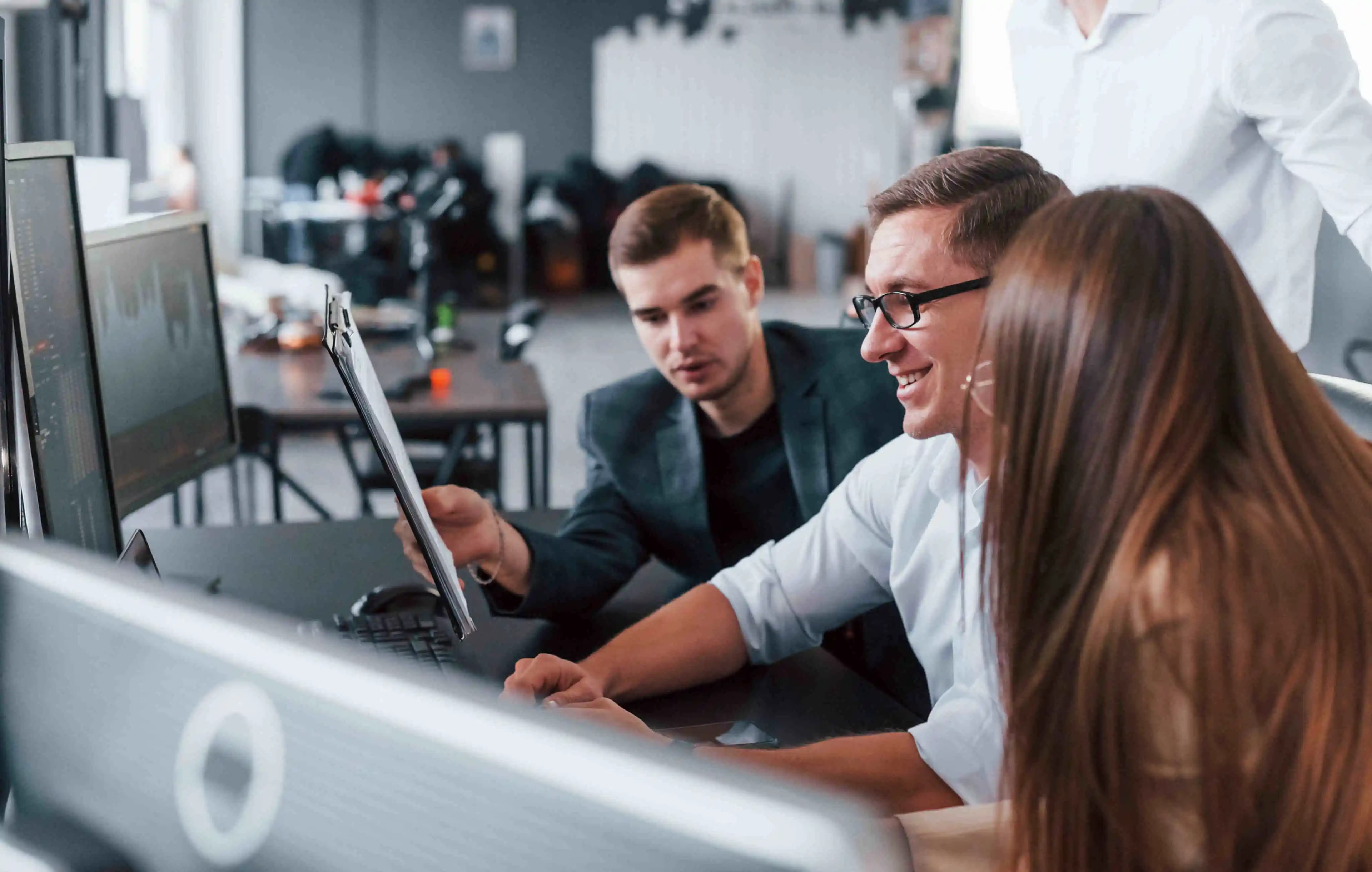 IT specialists immersed in their work, surrounded by technology in a modern office setting, where innovation meets efficiency.